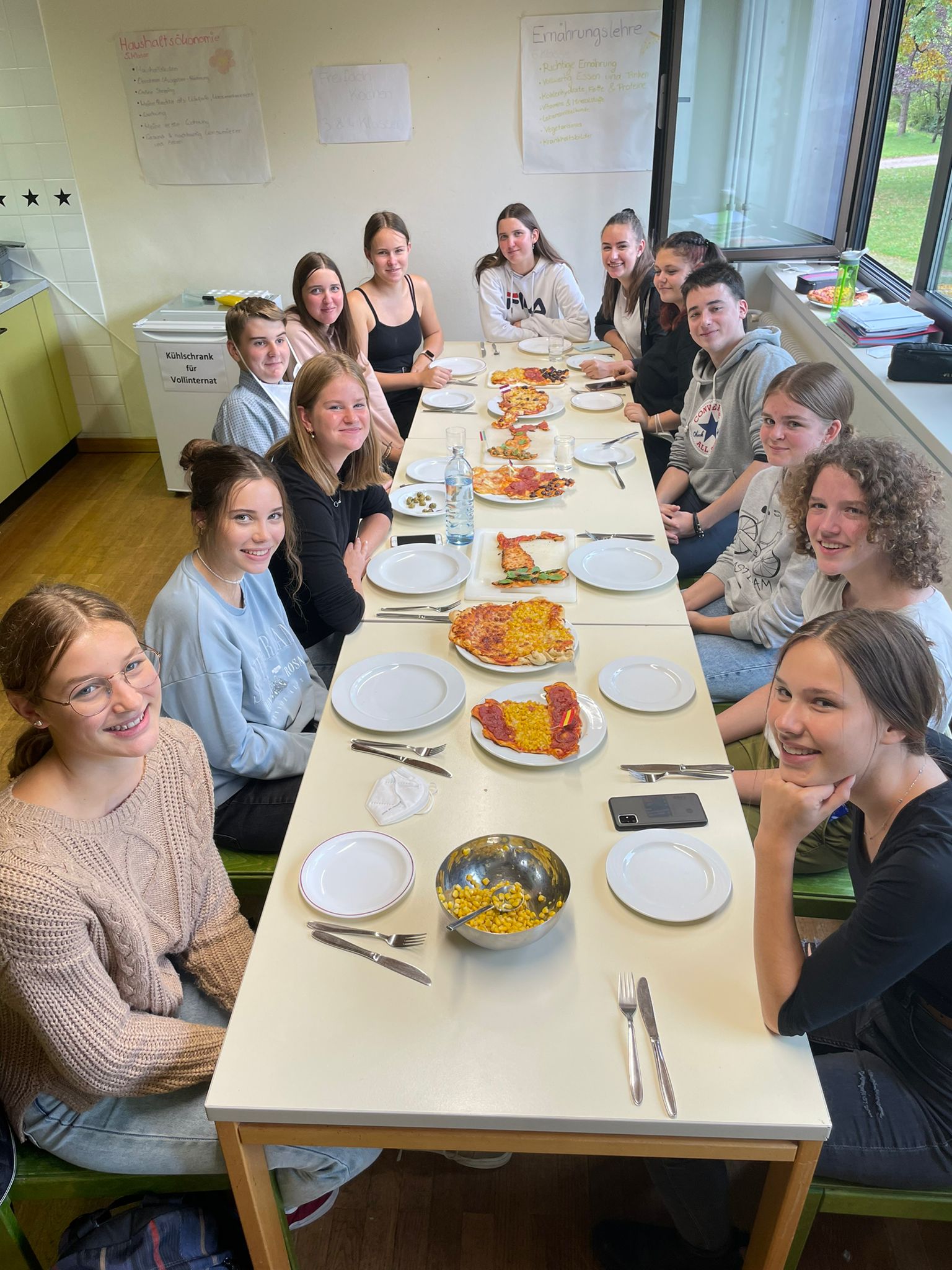 Schüler*innen vor dem Essen der selbst zubereiteten Pizzen