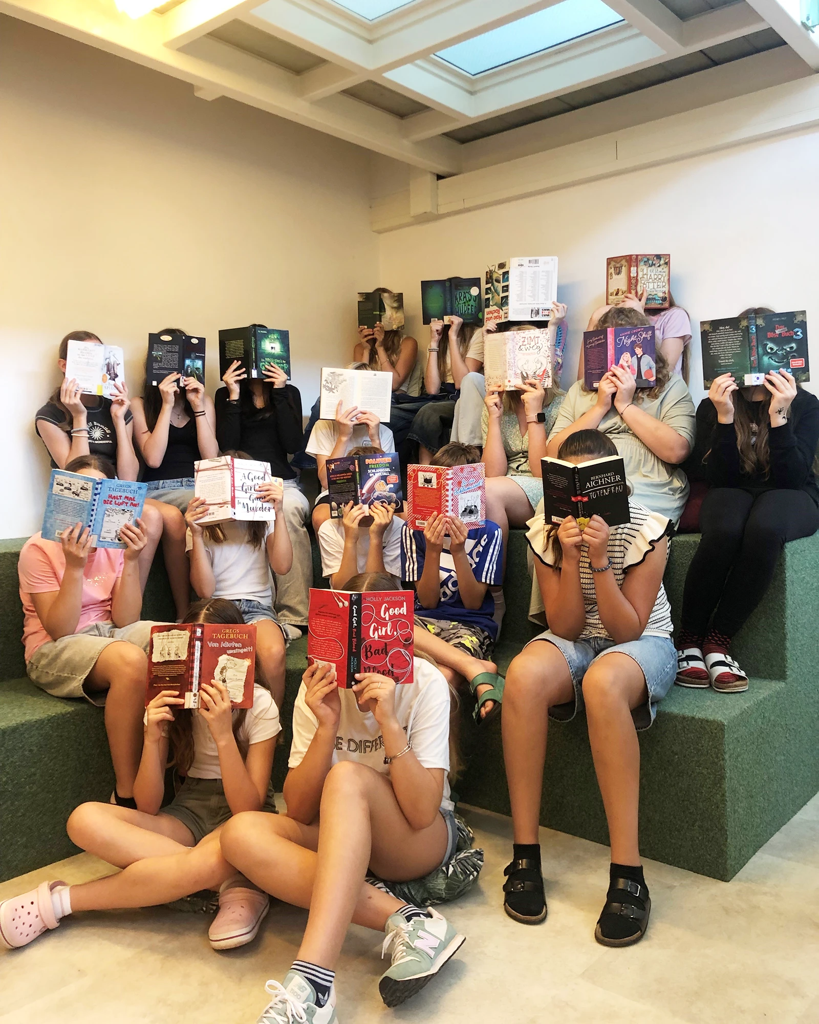 Schülerinnen halten Bücher in Bibliothek