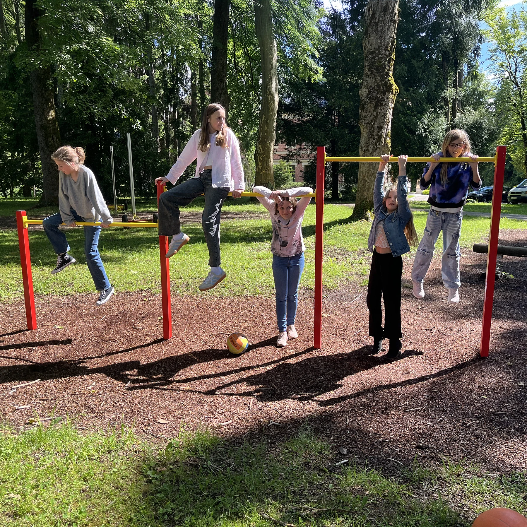 Schülerinnen turnen an Turnstangen