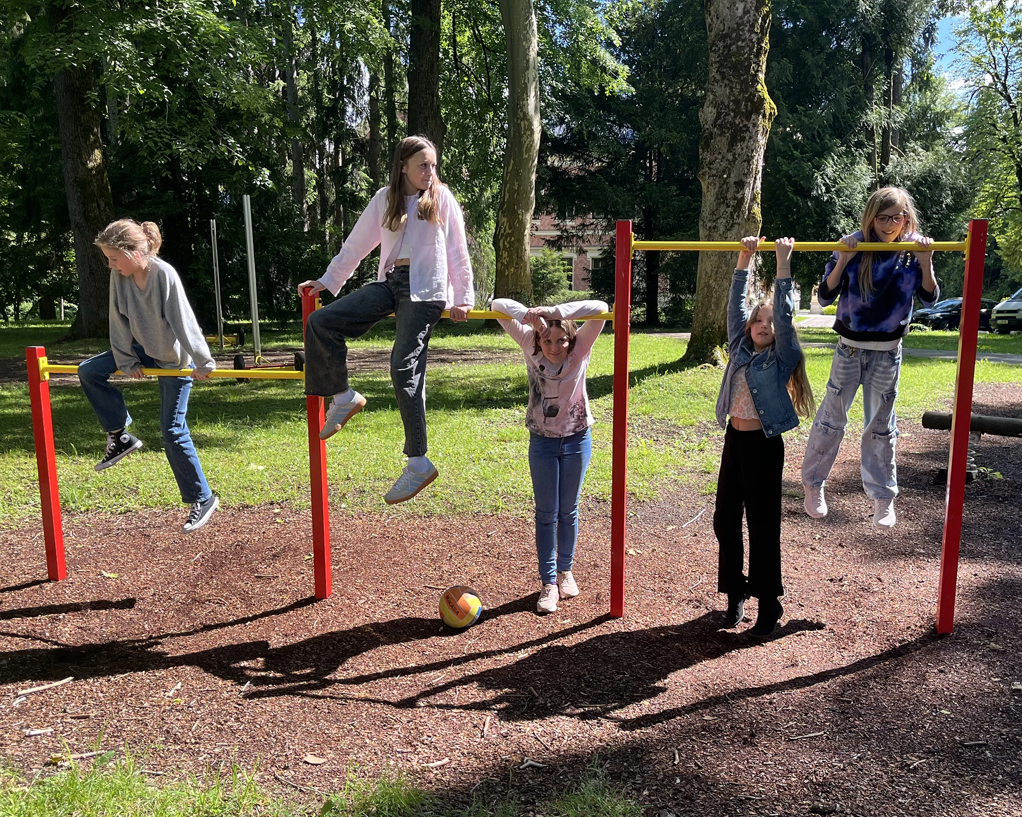 Schülerinnen turnen an Turnstangen