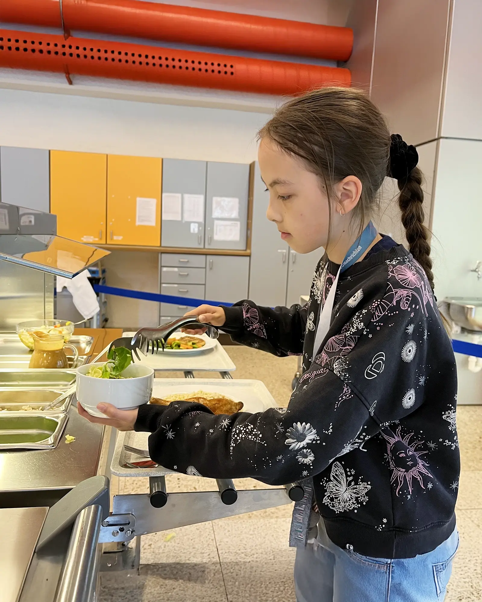 Schülerin nimmt sich gesundes Essen in der Schulkantine