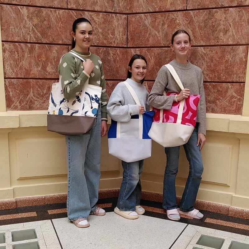 Schülerinnen mit selbst genähten Badetaschen