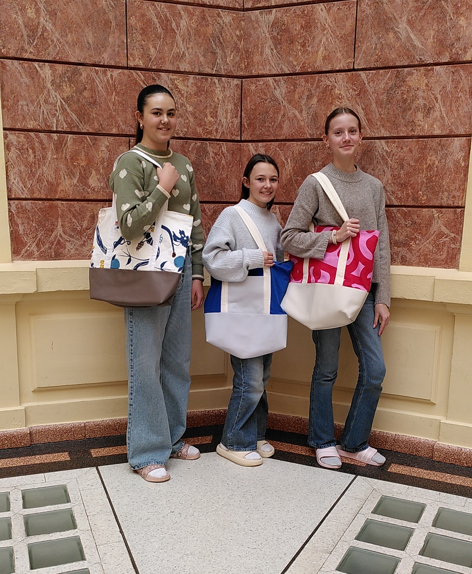 Schülerinnen mit selbst genähten Badetaschen