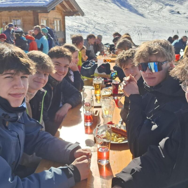 Skitag in Gosau - Schülerinnen und Schüler genießen die Sonne bei der wohlverdienten Pause