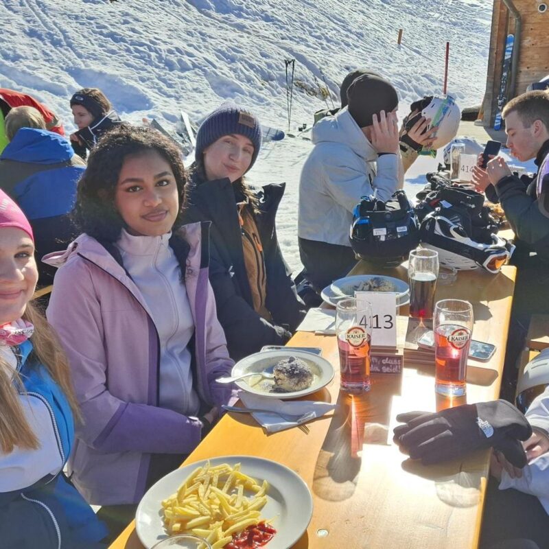 Skitag in Gosau - Schülerinnen und Schüler genießen die Sonne bei der wohlverdienten Pause